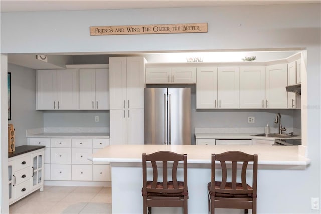 3153 Lake Pine Way Unit A1, Tarpon Springs, FL 34688 - kitchen featuring freestanding refrigerator, a peninsula, a breakfast bar area, and light countertops