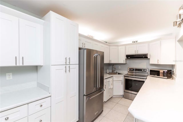 3153 Lake Pine Way Unit A1, Tarpon Springs, FL 34688 - kitchen featuring stainless steel appliances, under cabinet range hood, light countertops, light tile patterned flooring, and white cabinets