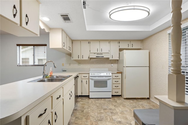 7700 Danube Dr Unit 7700, Hudson, FL 34667 - kitchen featuring white appliances, under cabinet range hood, light countertops, a raised ceiling, and cream cabinetry