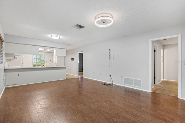 7700 Danube Dr Unit 7700, Hudson, FL 34667 - unfurnished living room featuring wood finished floors and a textured ceiling