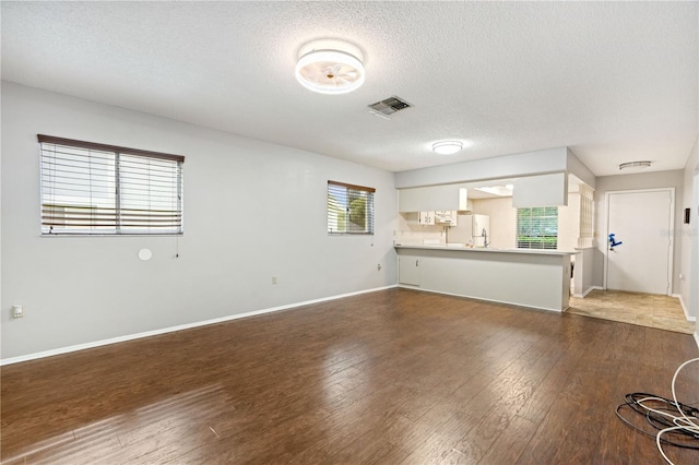 7700 Danube Dr Unit 7700, Hudson, FL 34667 - unfurnished living room with wood finished floors and a textured ceiling