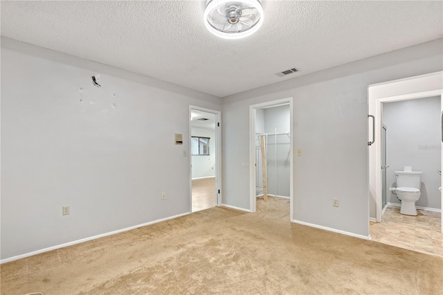 7700 Danube Dr Unit 7700, Hudson, FL 34667 - unfurnished bedroom with a spacious closet, light colored carpet, a textured ceiling, ensuite bathroom, and a closet