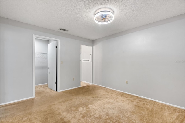 7700 Danube Dr Unit 7700, Hudson, FL 34667 - unfurnished bedroom featuring carpet flooring, a walk in closet, a textured ceiling, and a closet