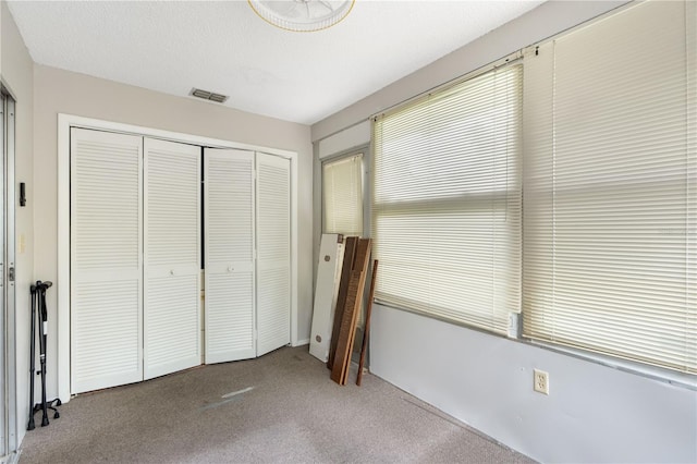 7700 Danube Dr Unit 7700, Hudson, FL 34667 - unfurnished bedroom featuring a closet, carpet, and multiple windows