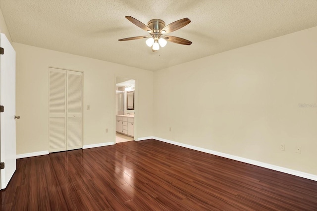 6654 Brambleleaf Dr, Spring Hill, FL 34606 - unfurnished bedroom with wood finished floors, a closet, a textured ceiling, ceiling fan, and ensuite bath