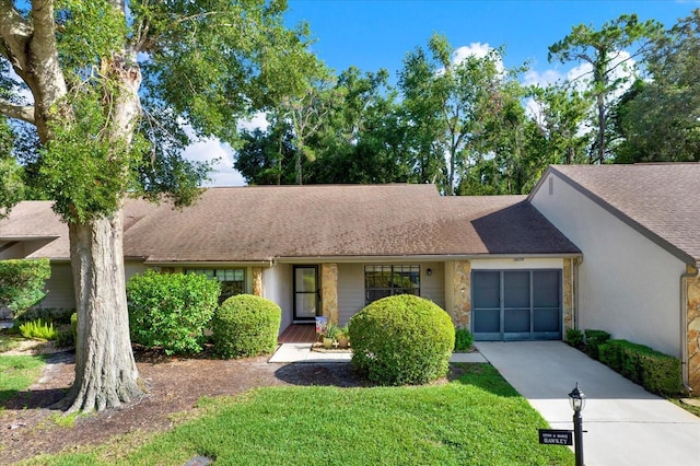 6654 Brambleleaf Dr, Spring Hill, FL 34606 - view of front of house with driveway, stone siding, a front yard, a shingled roof, and stucco siding