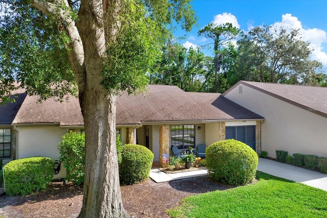6654 Brambleleaf Dr, Spring Hill, FL 34606 - view of front of house with a shingled roof and stucco siding