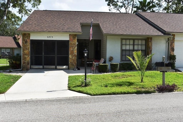6575 Brambleleaf Dr, Spring Hill, FL 34606 - view of front of house with roof with shingles, stone siding, and a front lawn