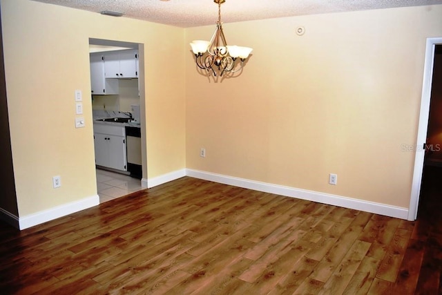 6575 Brambleleaf Dr, Spring Hill, FL 34606 - spare room featuring a chandelier, wood finished floors, and a textured ceiling