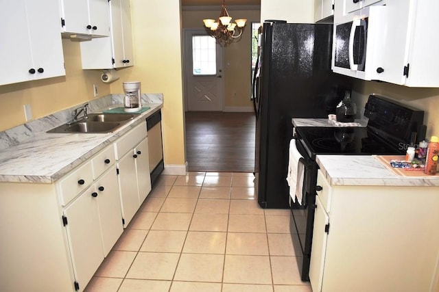 6575 Brambleleaf Dr, Spring Hill, FL 34606 - kitchen featuring black / electric stove, white microwave, a chandelier, white cabinetry, and light tile patterned floors