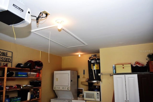 6575 Brambleleaf Dr, Spring Hill, FL 34606 - garage featuring stacked washer / drying machine, electric water heater, and a garage door opener