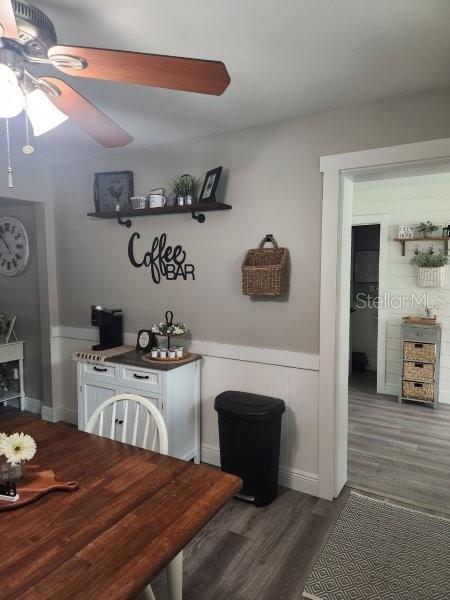 5710 Broadway Ave, New Port Richey, FL 34652 - dining area featuring ceiling fan, wood finished floors, and a wainscoted wall
