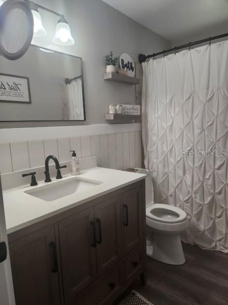 5710 Broadway Ave, New Port Richey, FL 34652 - bathroom with wood finished floors, vanity, and a shower with shower curtain