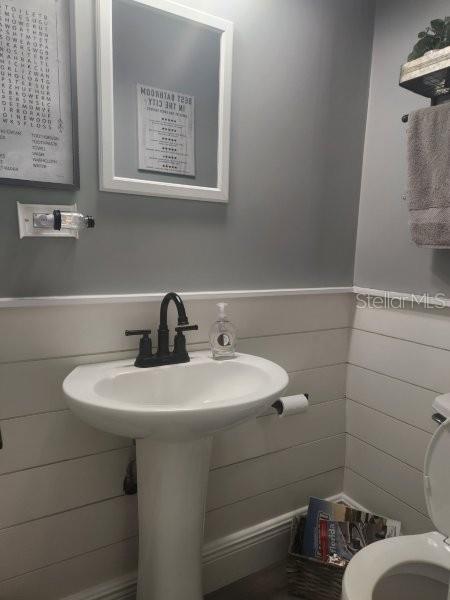 5710 Broadway Ave, New Port Richey, FL 34652 - bathroom featuring toilet and a wainscoted wall