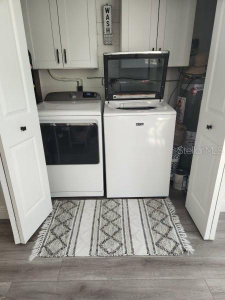 5710 Broadway Ave, New Port Richey, FL 34652 - laundry room featuring cabinet space, washer and clothes dryer, and light wood finished floors
