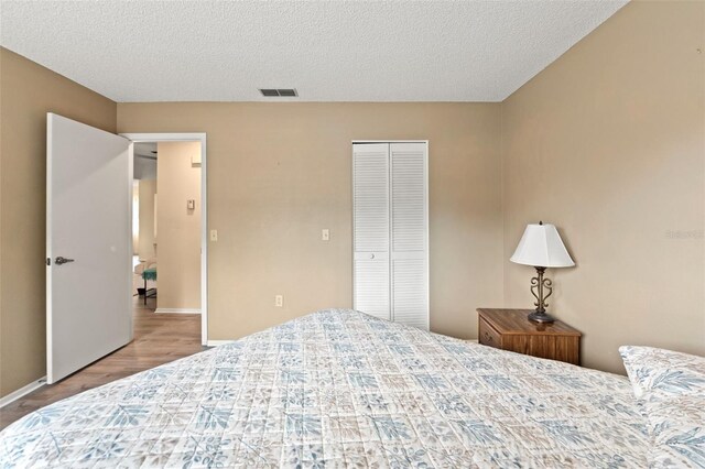 6085 Pekin Ct, Spring Hill, FL 34606 - bedroom with a closet, a textured ceiling, and wood finished floors
