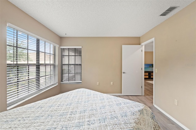 6085 Pekin Ct, Spring Hill, FL 34606 - bedroom with a textured ceiling and light wood-type flooring