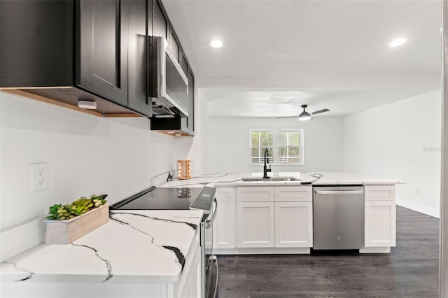 1324 Newhope Rd, Spring Hill, FL 34606 - kitchen with appliances with stainless steel finishes, a peninsula, dark wood-style flooring, light stone counters, and ceiling fan