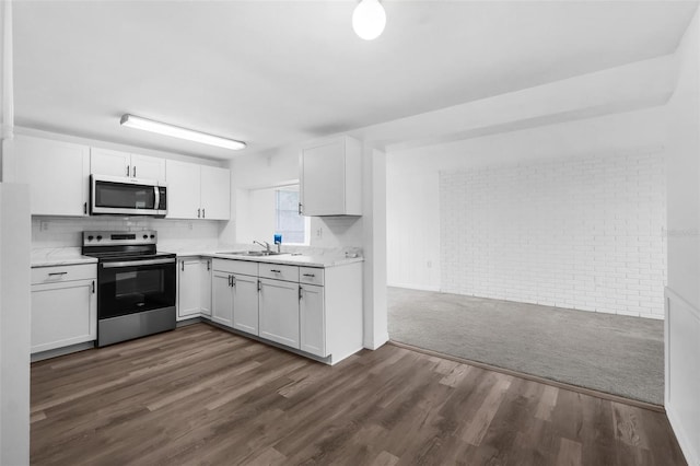 3528 Sheryl Hill Dr, Holiday, FL 34691 - kitchen featuring stainless steel appliances, light countertops, white cabinets, and dark wood-type flooring