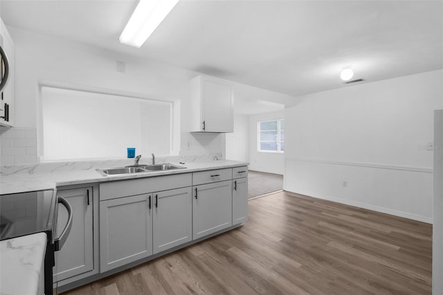 3528 Sheryl Hill Dr, Holiday, FL 34691 - kitchen with range with electric cooktop, wood finished floors, light stone countertops, and backsplash
