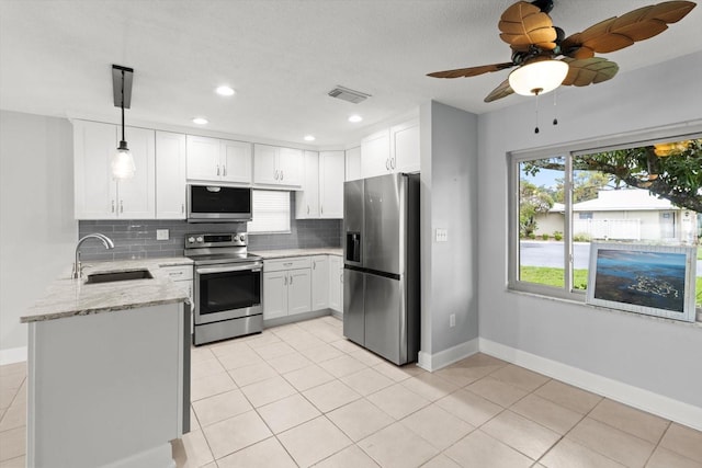 11446 W Bayshore Dr Unit 36, Crystal River, FL 34429 - kitchen with appliances with stainless steel finishes, backsplash, light stone countertops, white cabinetry, and light tile patterned floors