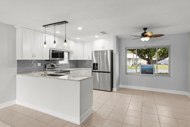11446 W Bayshore Dr Unit 36, Crystal River, FL 34429 - kitchen with stainless steel appliances, backsplash, a peninsula, light stone countertops, and white cabinetry