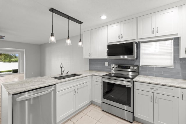11446 W Bayshore Dr Unit 36, Crystal River, FL 34429 - kitchen with appliances with stainless steel finishes, a peninsula, tasteful backsplash, light tile patterned flooring, and white cabinets