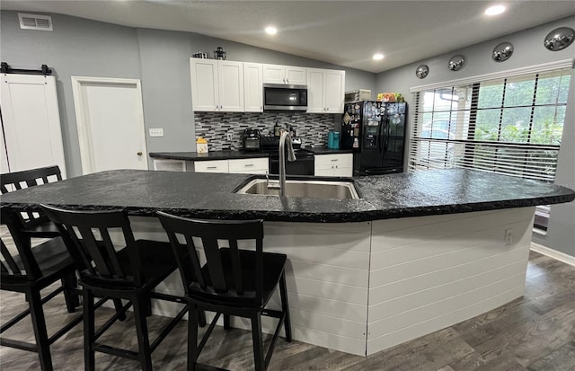 8122 Matthew Dr, New Port Richey, FL 34653 - kitchen with stainless steel microwave, black fridge with ice dispenser, tasteful backsplash, white cabinetry, and dark wood-style floors