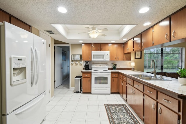 18531 Ozark Dr, Hudson, FL 34667 - kitchen featuring white appliances, brown cabinetry, a raised ceiling, crown molding, and a ceiling fan