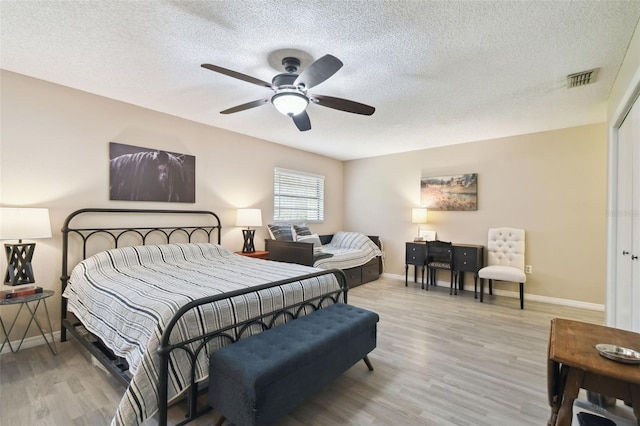 18531 Ozark Dr, Hudson, FL 34667 - bedroom featuring light wood-style floors, a textured ceiling, and ceiling fan