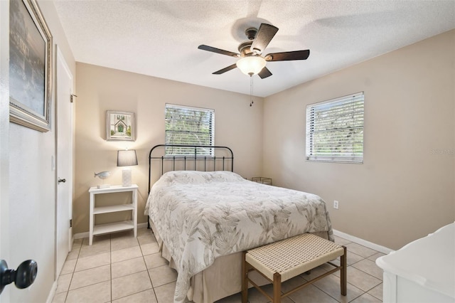 18531 Ozark Dr, Hudson, FL 34667 - bedroom featuring multiple windows, light tile patterned flooring, a textured ceiling, and a ceiling fan