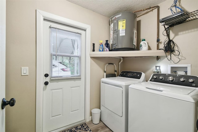 18531 Ozark Dr, Hudson, FL 34667 - laundry room featuring electric water heater, washer and clothes dryer, a textured ceiling, and light wood-type flooring
