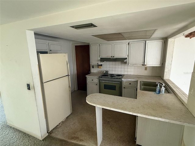 12813 Vassar Ct, Hudson, FL 34667 - kitchen with freestanding refrigerator, range with electric cooktop, under cabinet range hood, a peninsula, and light countertops
