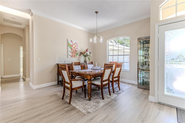 5301 Legend Hills Ln, Spring Hill, FL 34609 - dining space featuring arched walkways, light wood-style flooring, and ornamental molding