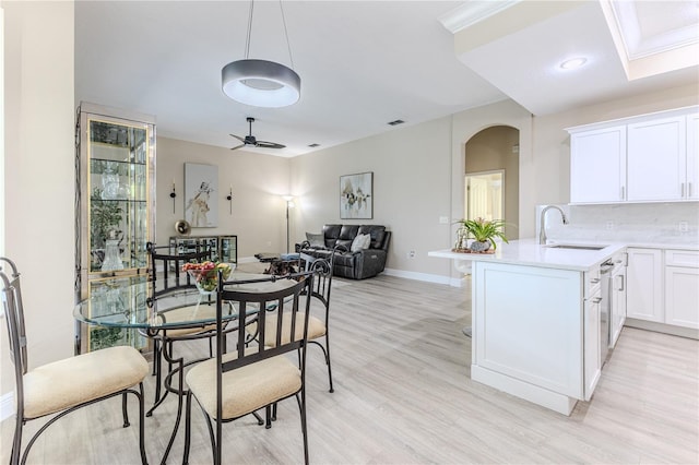 5301 Legend Hills Ln, Spring Hill, FL 34609 - dining room with arched walkways, light wood-style flooring, and ceiling fan