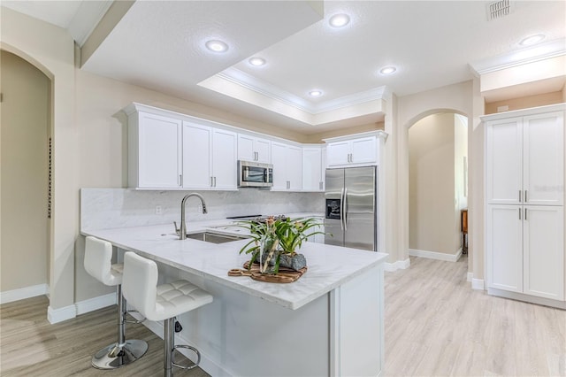 5301 Legend Hills Ln, Spring Hill, FL 34609 - kitchen featuring appliances with stainless steel finishes, arched walkways, a peninsula, crown molding, and decorative backsplash