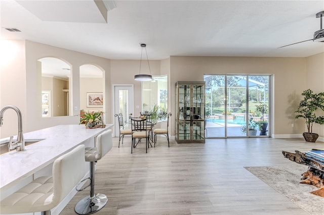 5301 Legend Hills Ln, Spring Hill, FL 34609 - dining area with light wood-type flooring and arched walkways