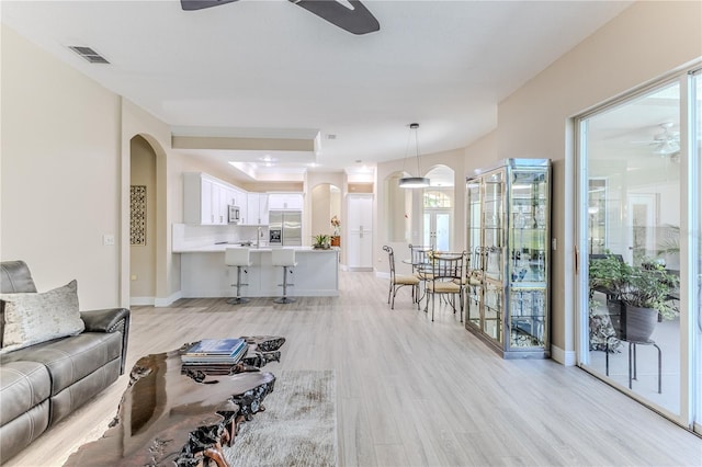 5301 Legend Hills Ln, Spring Hill, FL 34609 - living room featuring a ceiling fan, arched walkways, and light wood-style flooring