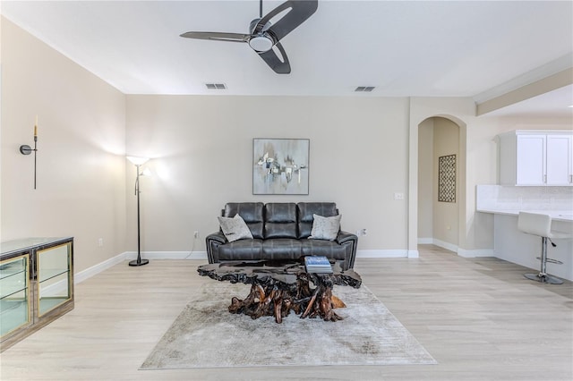 5301 Legend Hills Ln, Spring Hill, FL 34609 - living room featuring arched walkways, light wood-style flooring, and a ceiling fan