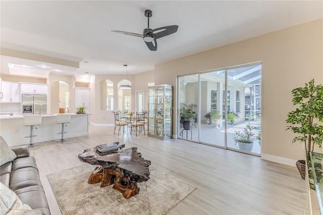 5301 Legend Hills Ln, Spring Hill, FL 34609 - living room with arched walkways, plenty of natural light, light wood-type flooring, and ceiling fan