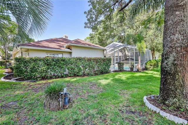 5301 Legend Hills Ln, Spring Hill, FL 34609 - view of home's exterior with stucco siding, a chimney, a yard, a pool, and a lanai