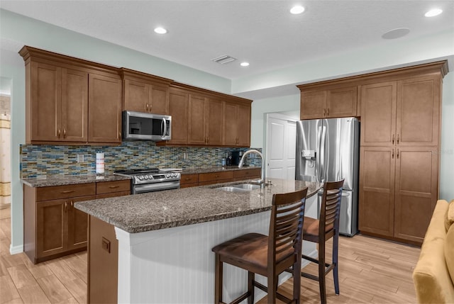 9863 Deer St, Spring Hill, FL 34608 - kitchen with stainless steel appliances, light wood finished floors, dark stone countertops, tasteful backsplash, and recessed lighting