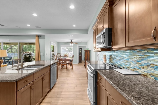 9863 Deer St, Spring Hill, FL 34608 - kitchen with stainless steel appliances, backsplash, healthy amount of natural light, recessed lighting, and dark stone countertops