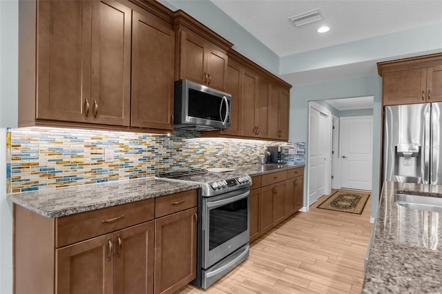 9863 Deer St, Spring Hill, FL 34608 - kitchen featuring stainless steel appliances, light wood finished floors, light stone counters, decorative backsplash, and recessed lighting