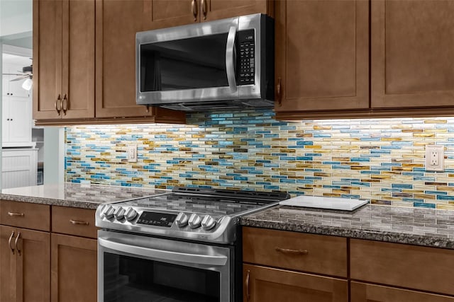 9863 Deer St, Spring Hill, FL 34608 - kitchen featuring stainless steel appliances, ceiling fan, decorative backsplash, and dark stone countertops