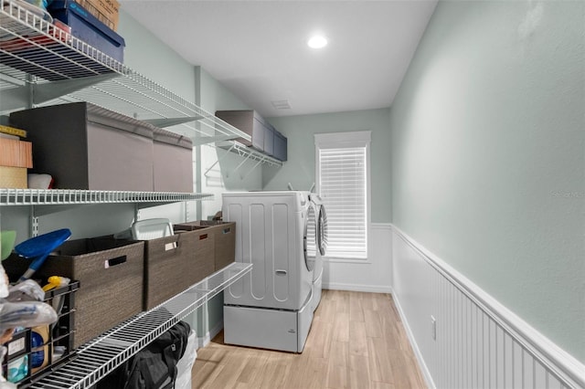 9863 Deer St, Spring Hill, FL 34608 - laundry room featuring washer and clothes dryer, wainscoting, and light wood-type flooring