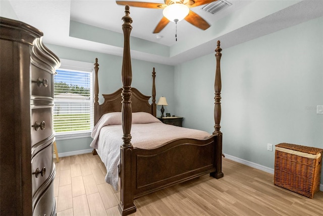 9863 Deer St, Spring Hill, FL 34608 - bedroom featuring a tray ceiling, light wood-type flooring, and ceiling fan