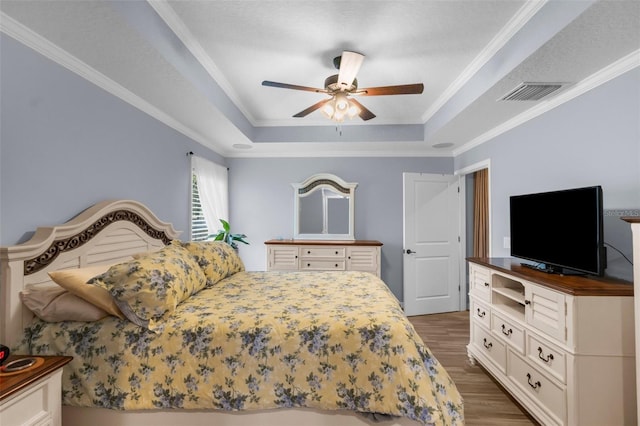 9863 Deer St, Spring Hill, FL 34608 - bedroom featuring a tray ceiling, dark wood-style floors, ornamental molding, and a ceiling fan