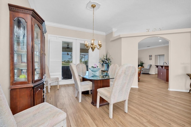 1610 Winding Willow Dr, Trinity, FL 34655 - dining room with crown molding, light wood-style floors, a chandelier, and arched walkways