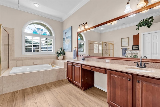 1610 Winding Willow Dr, Trinity, FL 34655 - bathroom featuring a stall shower, double vanity, wood finished floors, a garden tub, and crown molding